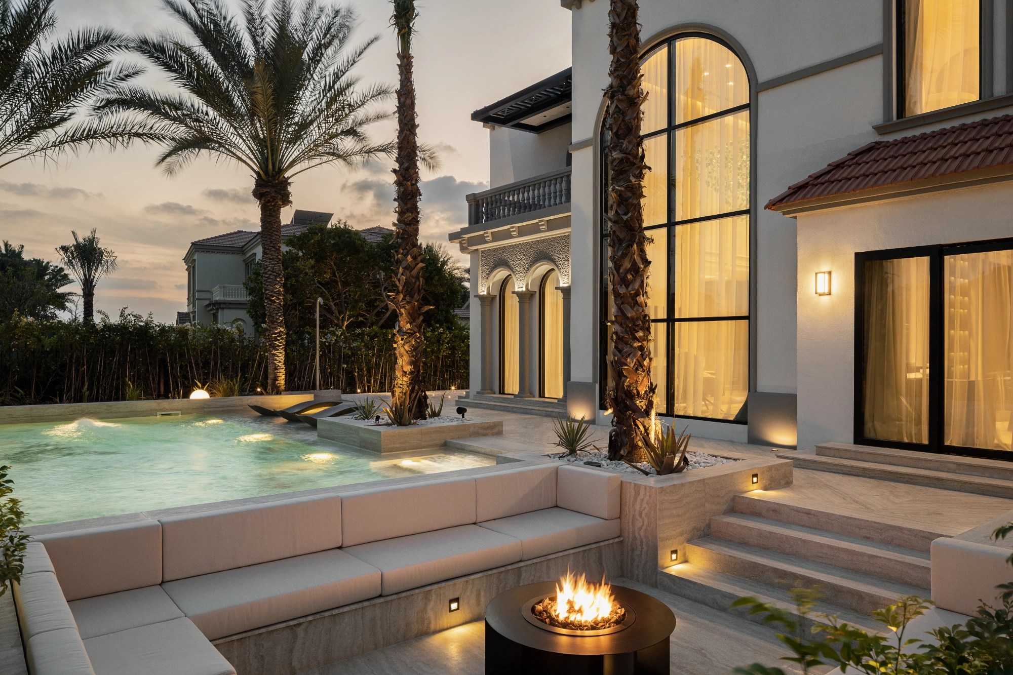 Villa Octavia pool terrace at dusk with sunken lounge and fire pit