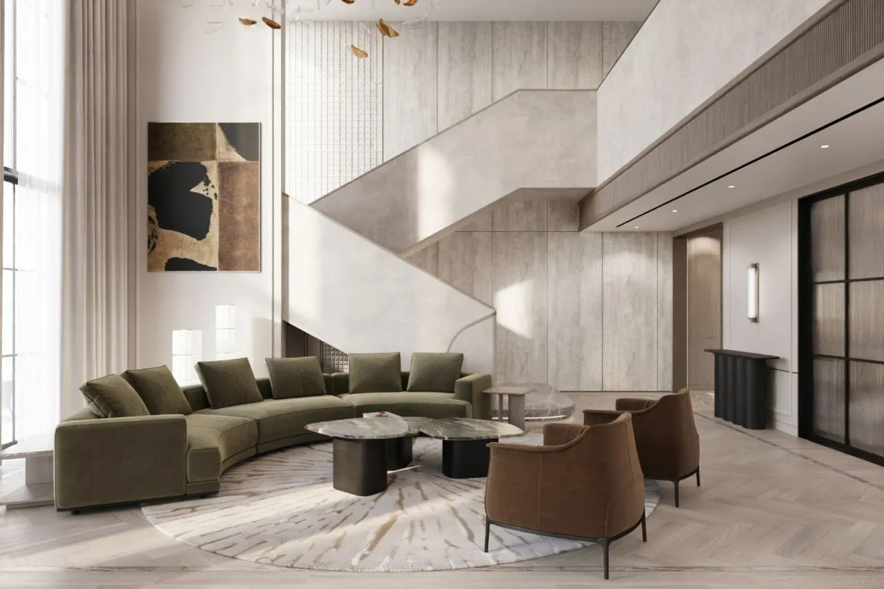 Living room looking through a radiused bronze-edged arch to the kitchen island, with olive sofa and herringbone oak floor