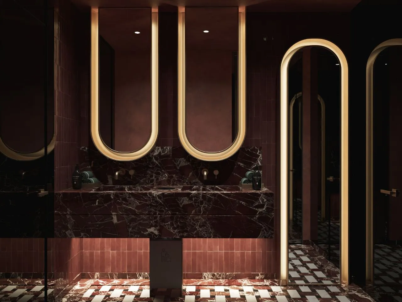 Female washroom with a rosso marble vanity, terracotta tile and three illuminated arched mirrors