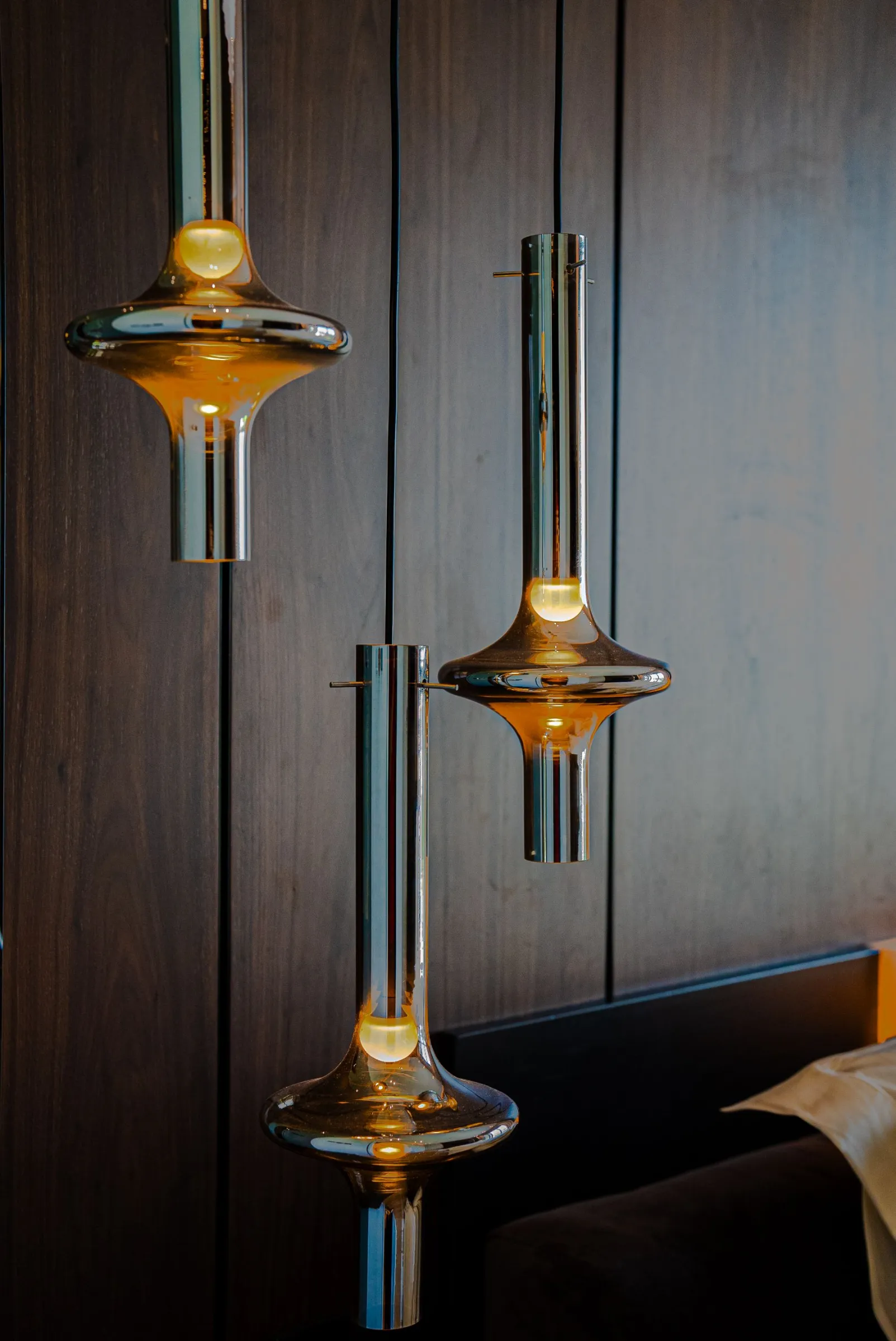 Sculptural chrome and amber glass pendants in the master bedroom