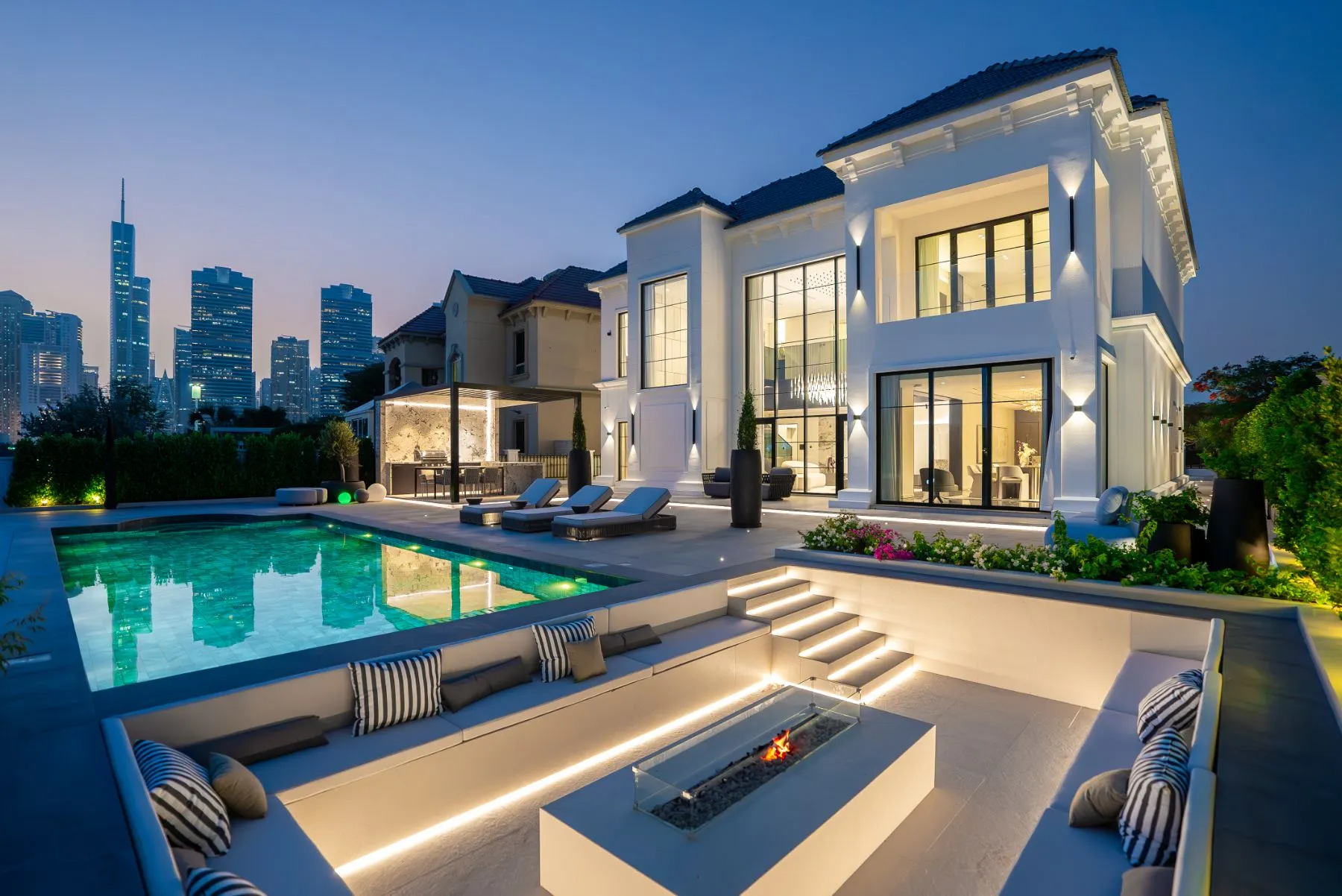 Illuminated villa, pool and skyline at dusk