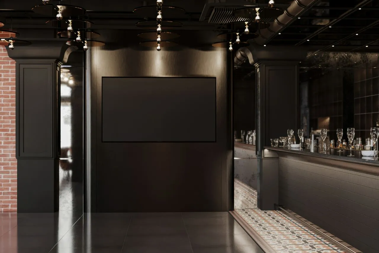 Backbar wall of backlit cast panels carrying a repeating bull motif, filled with bottles and glassware