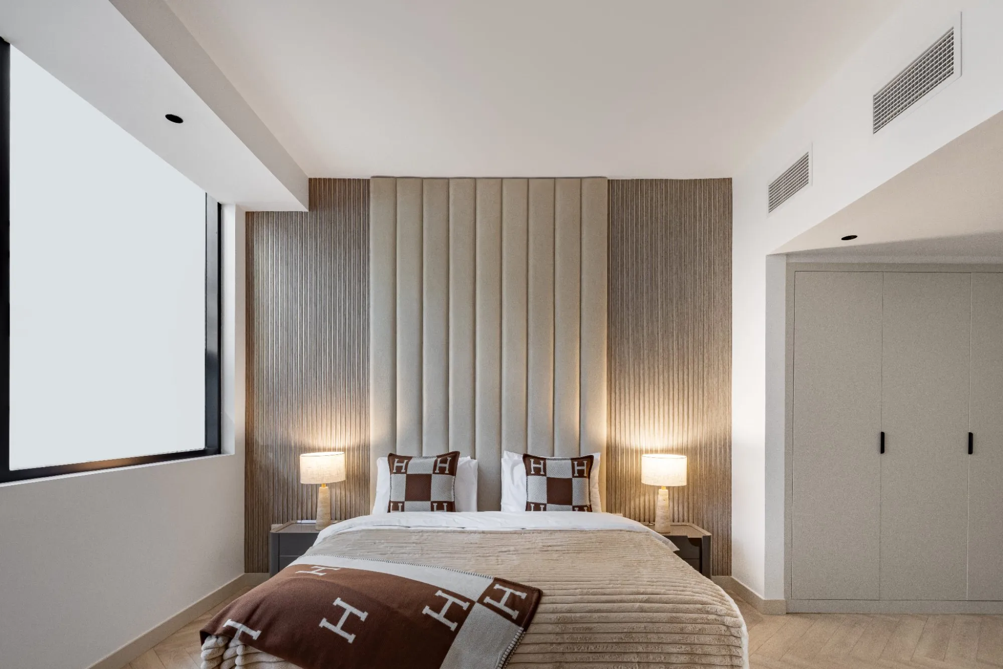 Guest bedroom with bespoke joinery and warm lighting