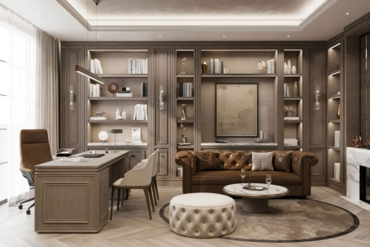 Study and library with lit oak bookcases, a panelled desk, tan Chesterfield sofa, tufted ottoman and marble fireplace