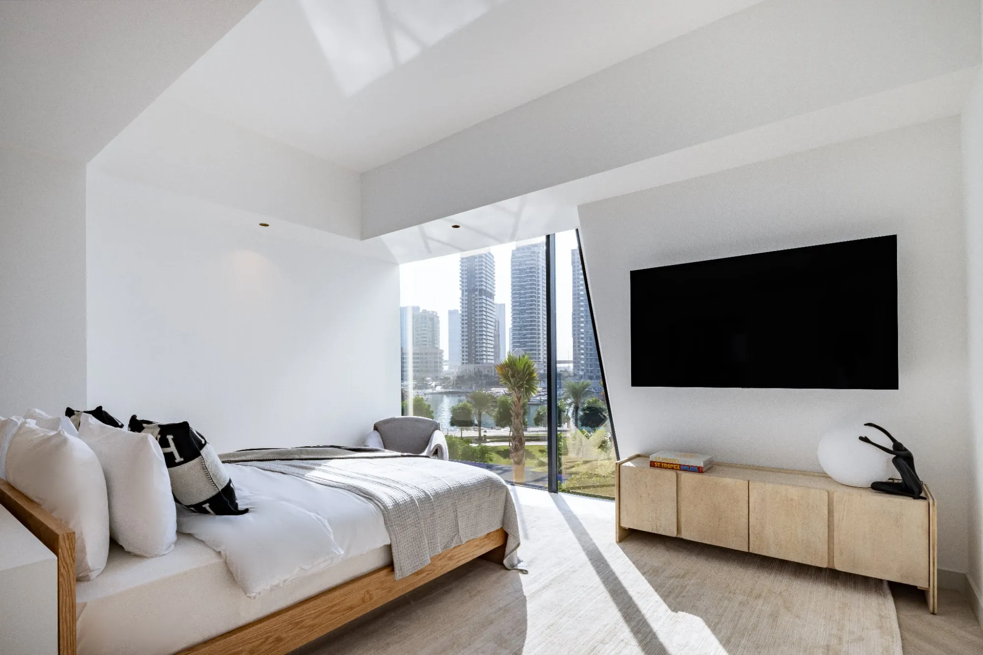 Principal bedroom with upholstered headboard and warm joinery