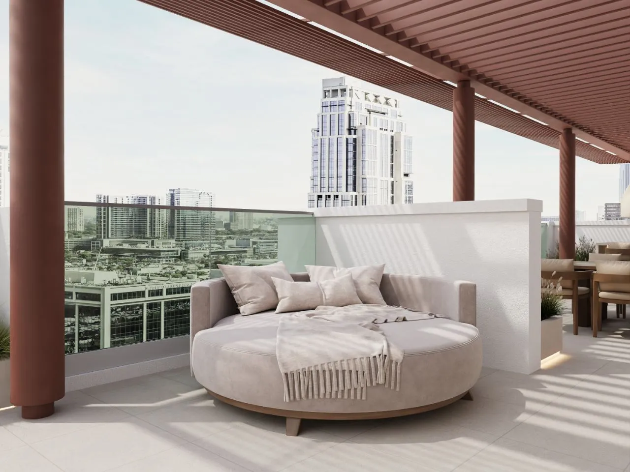 Round teak daybed with sand cushions on the roof terrace, framed by terracotta pergola columns and a glass balustrade over the city