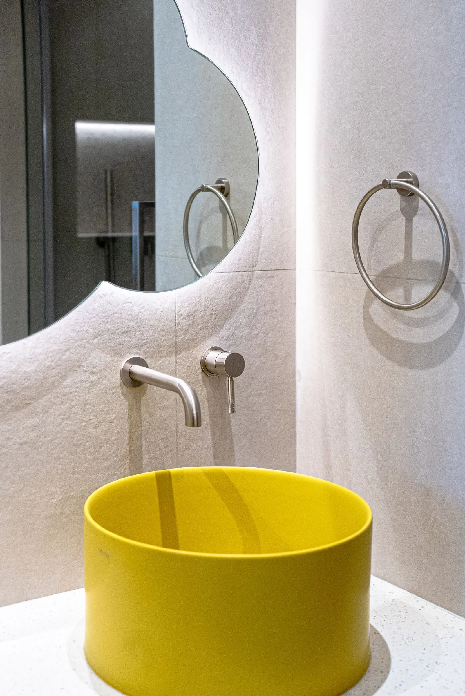 Playful curved stone bathroom with a saffron basin