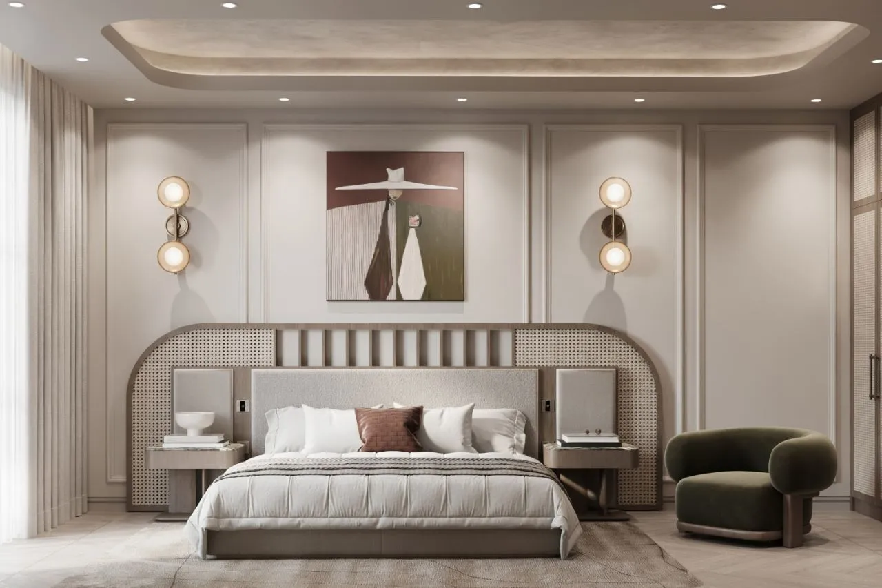 Guest bedroom with an arched cane and oak headboard wall, brass globe sconces and an olive velvet armchair