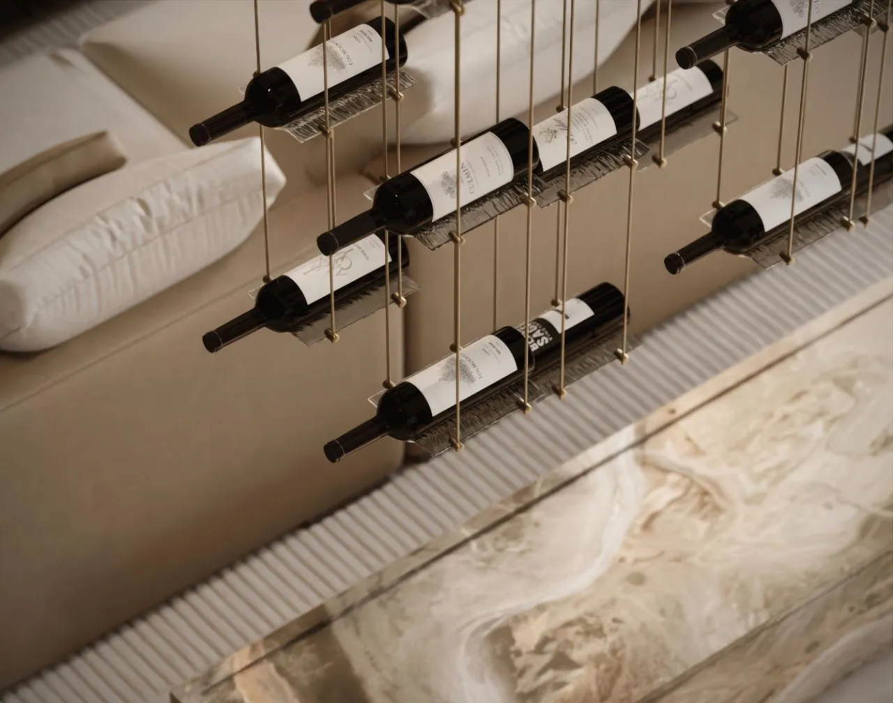 Close view of the suspended wine display, bottles held in clear acrylic cradles on tensioned brass cables against a sand plaster wall