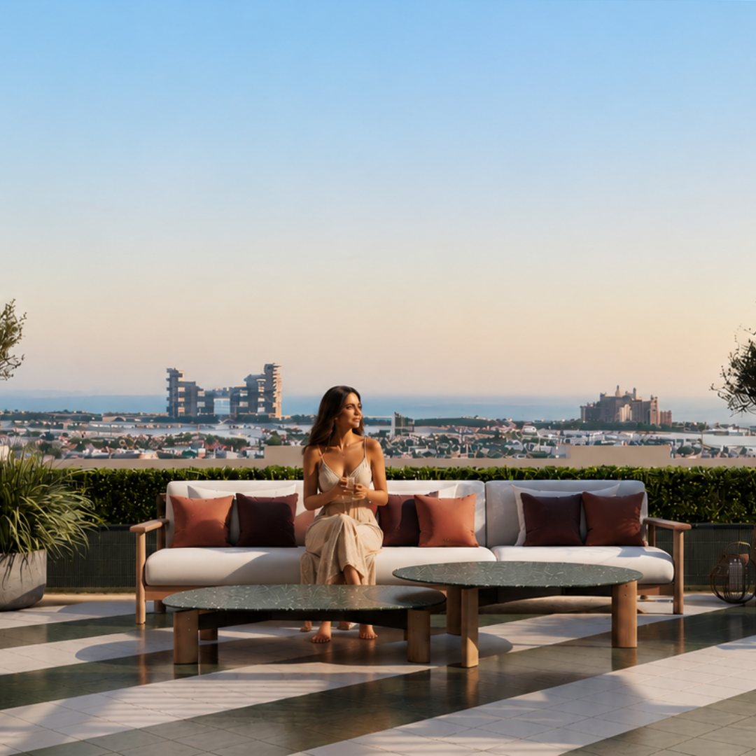 Penthouse terrace at sunset with checkerboard stone paving, teak sofa and views across Palm Jumeirah