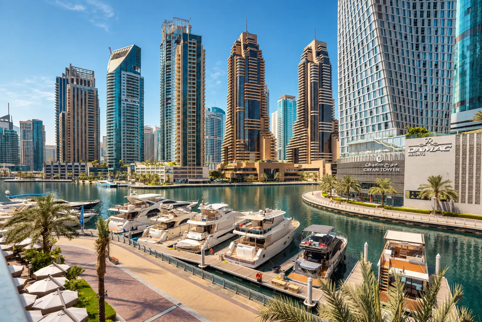 Dubai Marina promenade with yachts moored along the water and towers rising beyond