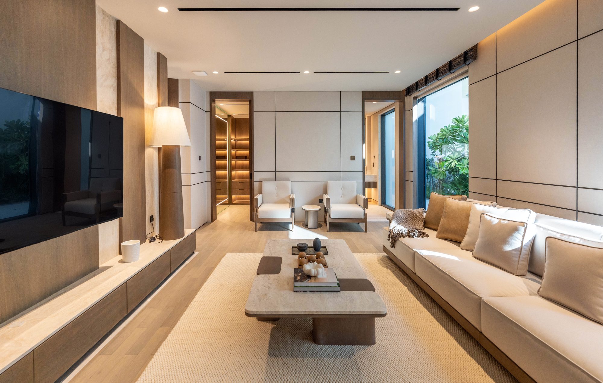 Media lounge with panelled walls and garden view