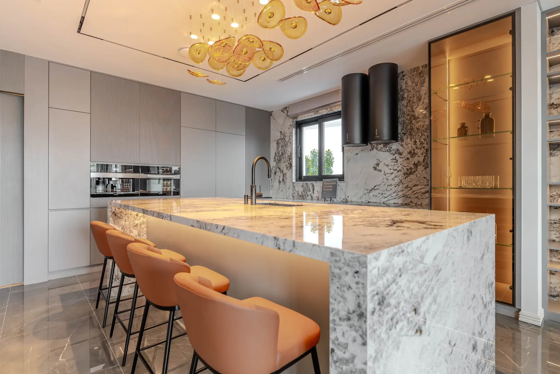 Marble island kitchen with amber glass pendants