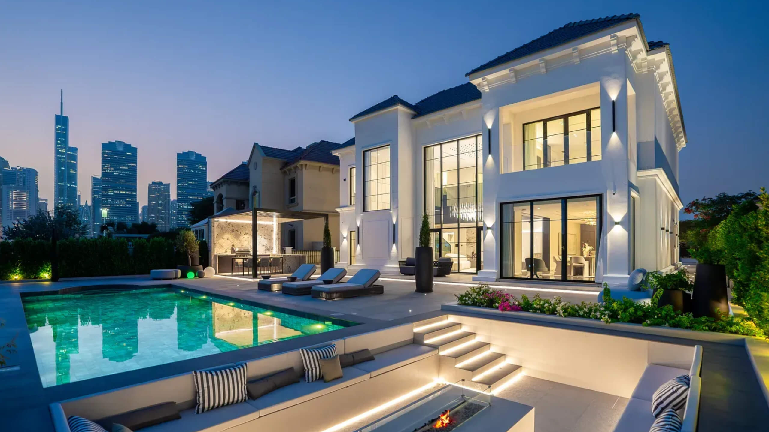 Twilight pool terrace and fire pit at a K4 villa overlooking the Dubai skyline