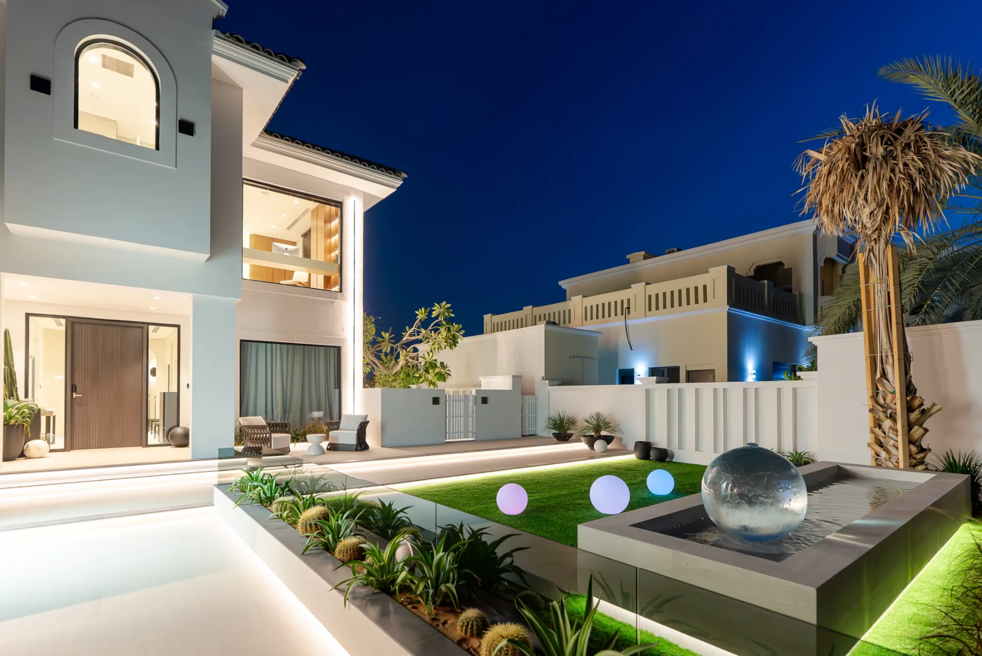 Landscaped garden and water feature illuminated at night