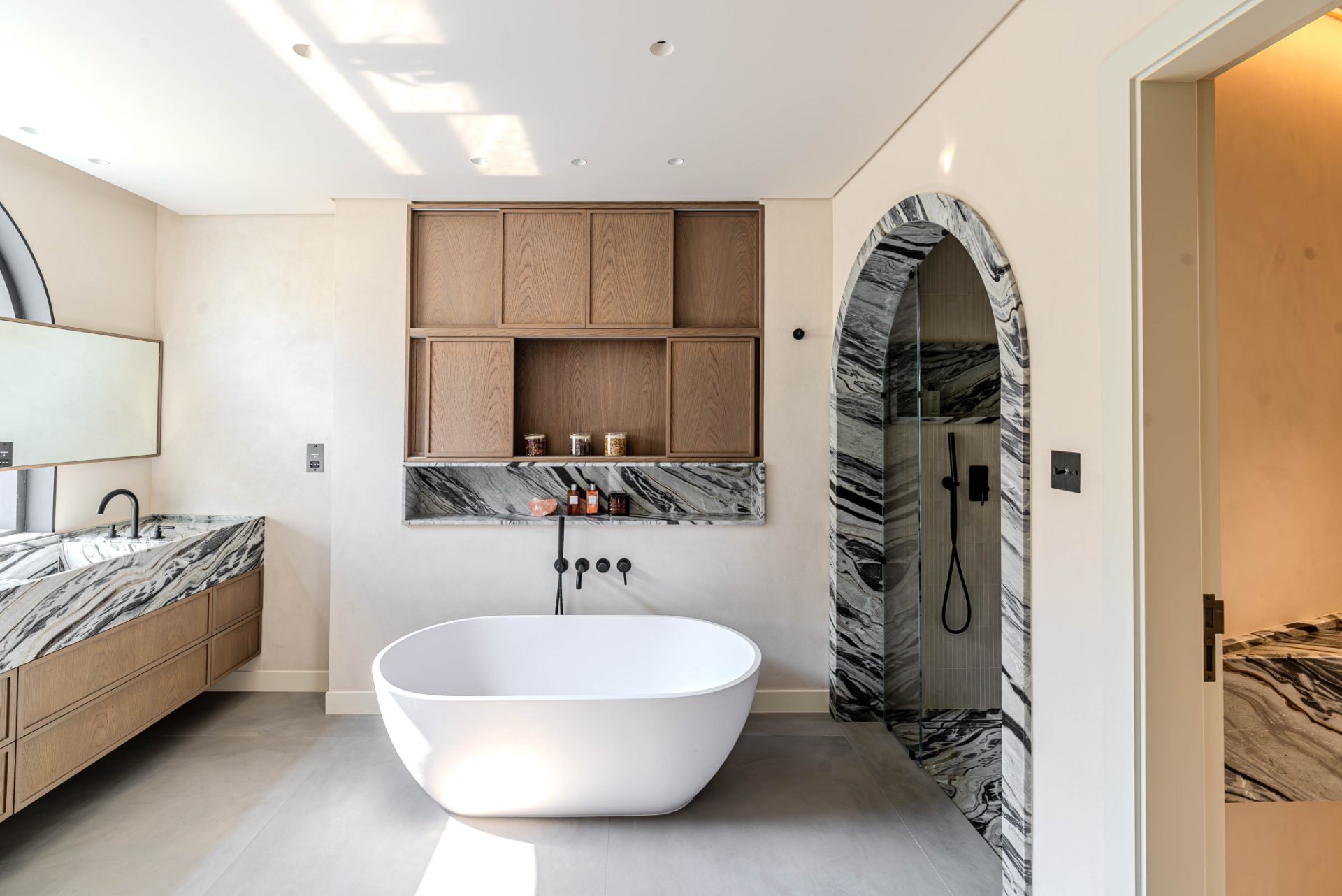 Principal spa bath with marble shower arch