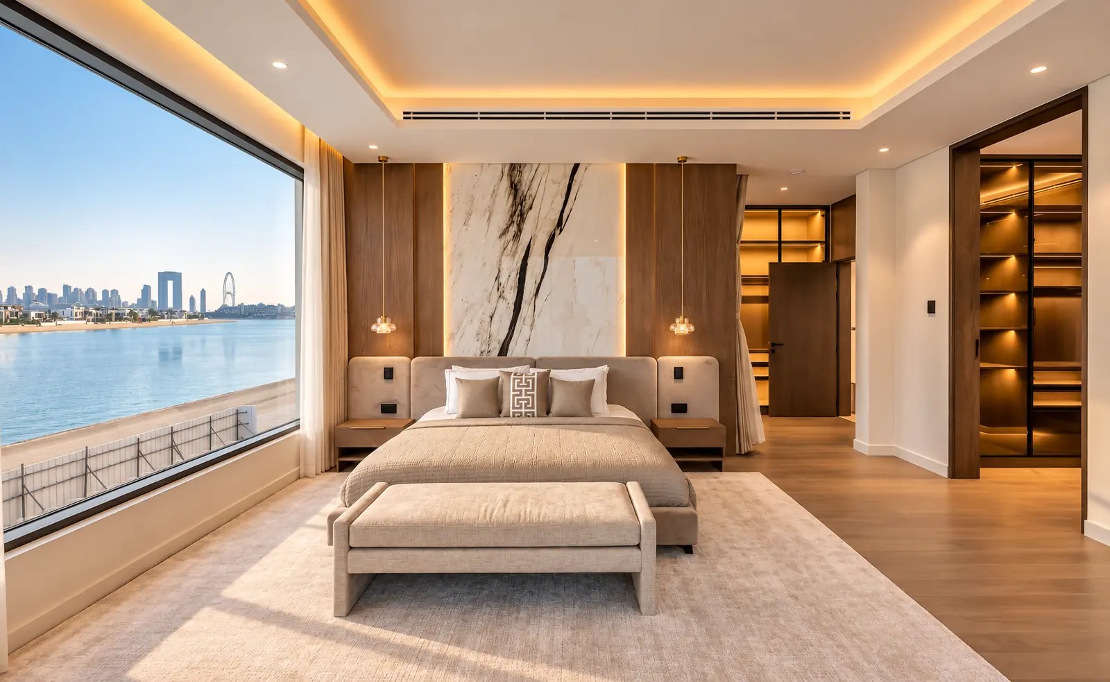 Master bedroom with a book-matched marble feature wall, walnut panelling, upholstered bed and a lit walk-in wardrobe