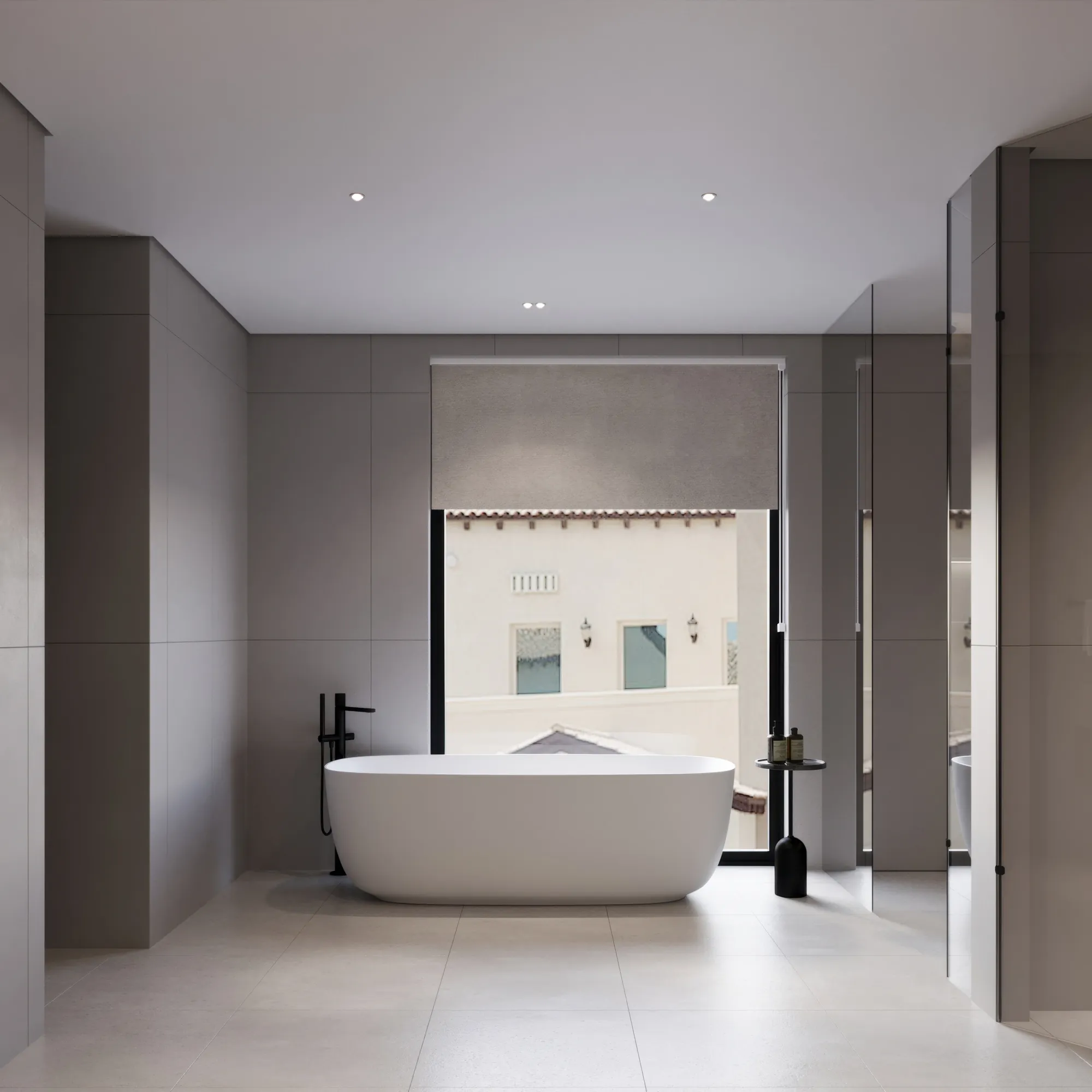 Master bathroom in large-format stone with a freestanding bath and black fittings