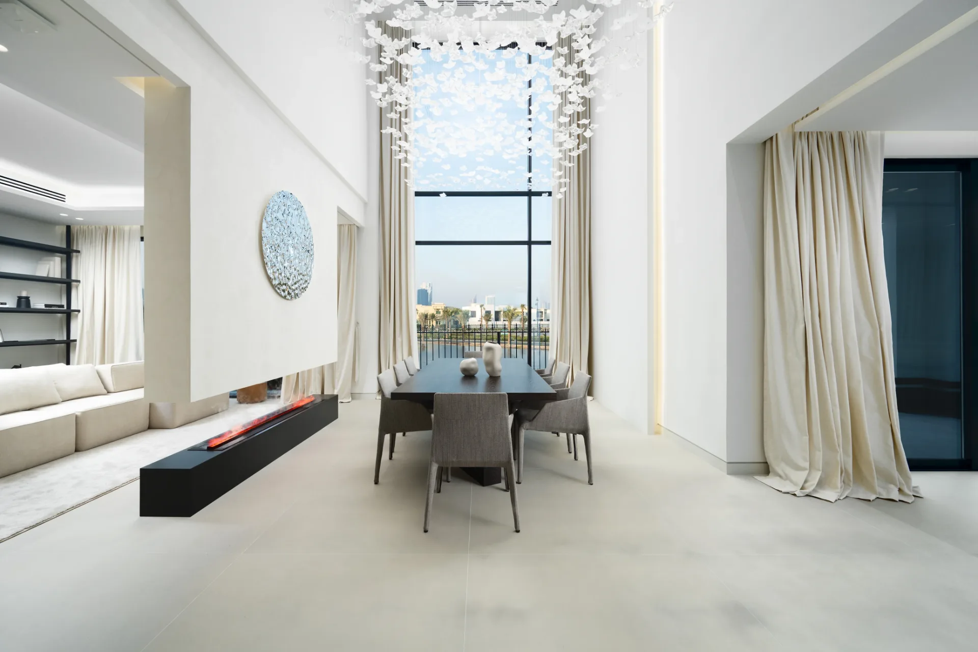 Double-height dining room with butterfly chandelier and lake view