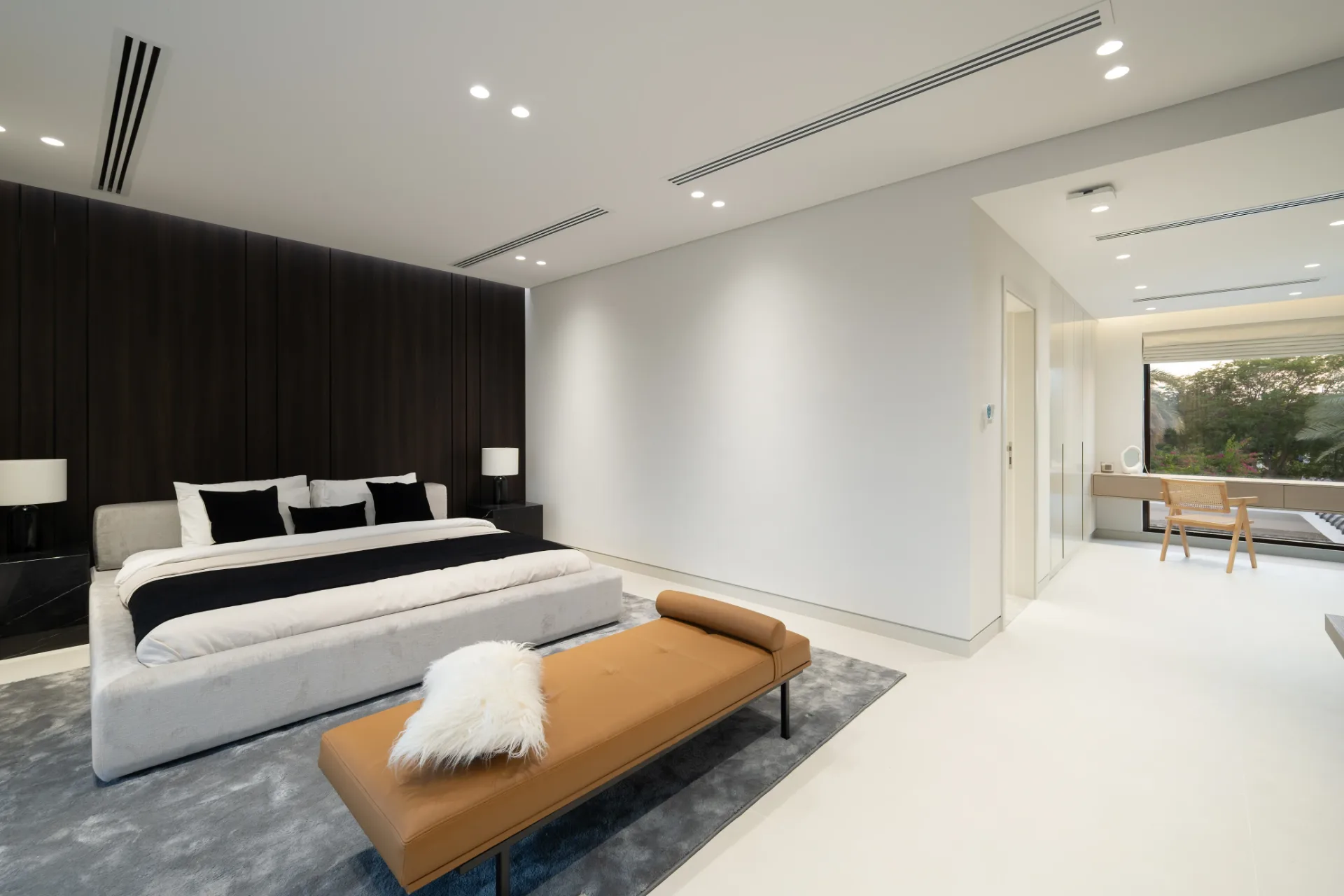 Principal bedroom with timber feature wall and tan daybed