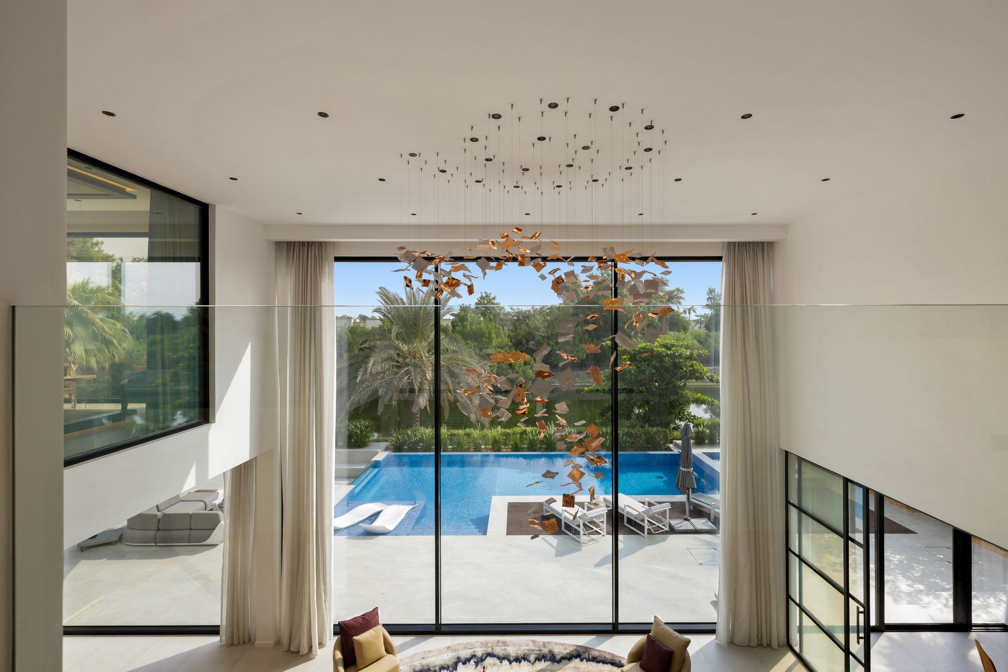 Gallery view over the double-height living room and pool
